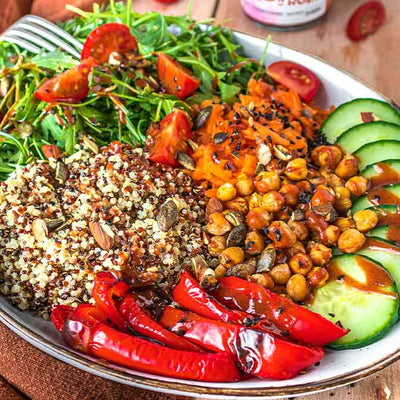 Buddha Bowl mit gerösteter Paprika, Rucola, Quinoa und Moroc'n'Roll Sauce für Gemüse